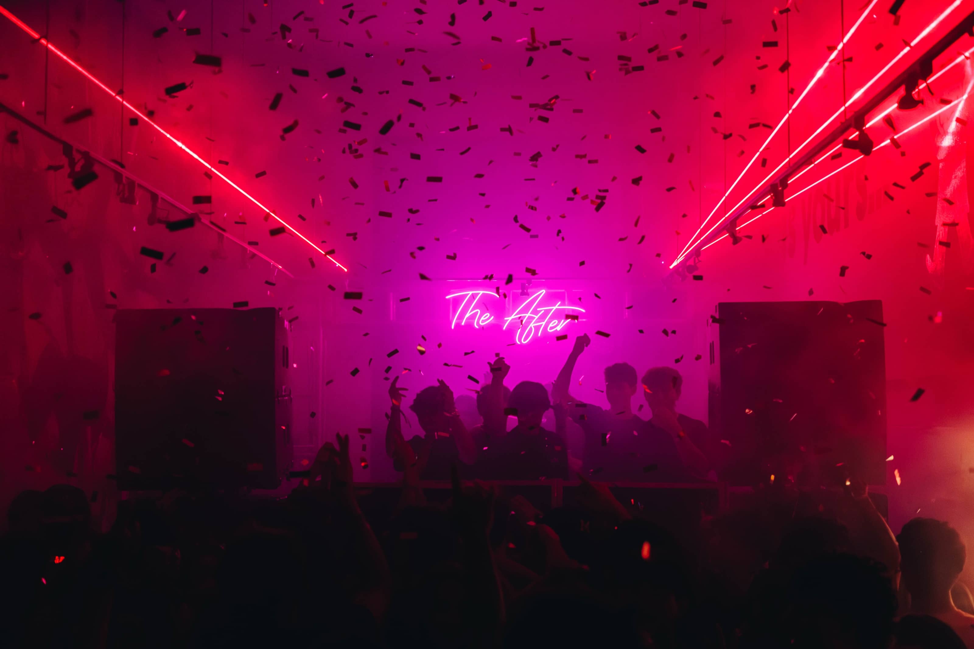 Confetti drop under red lasers with The After neon sign lit