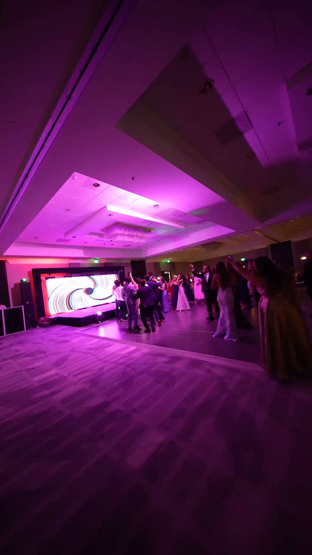 Gala guests on a purple-lit dance floor in front of the LED wall and stage