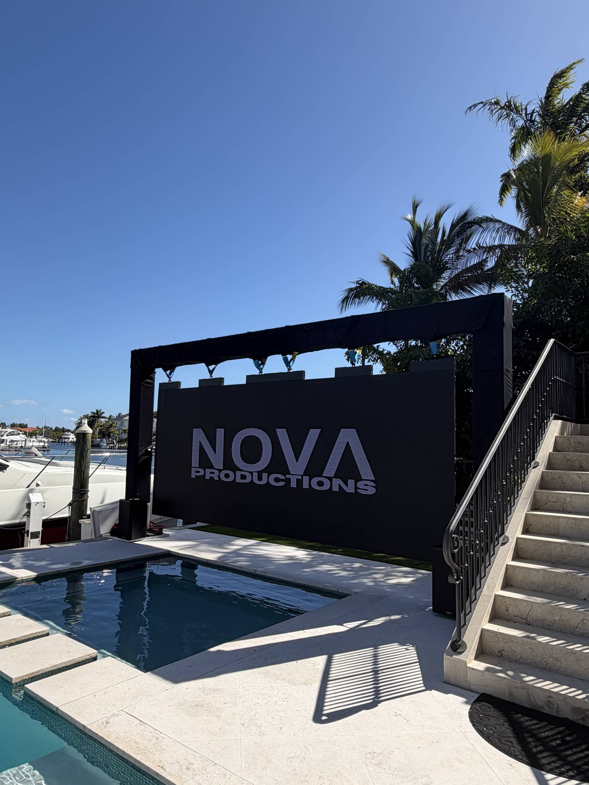 Nova's LED wall running the Nova Productions wordmark over an estate pool